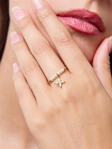 Guldfarvet justerbar ring med perler og blomst charm set forfra